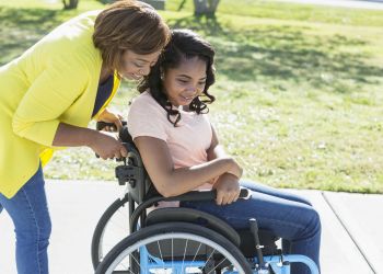 Mother with teenage daughter wheelchair disability i Stock 844299986