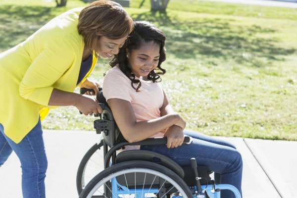 Mother with teenage daughter wheelchair disability i Stock 844299986